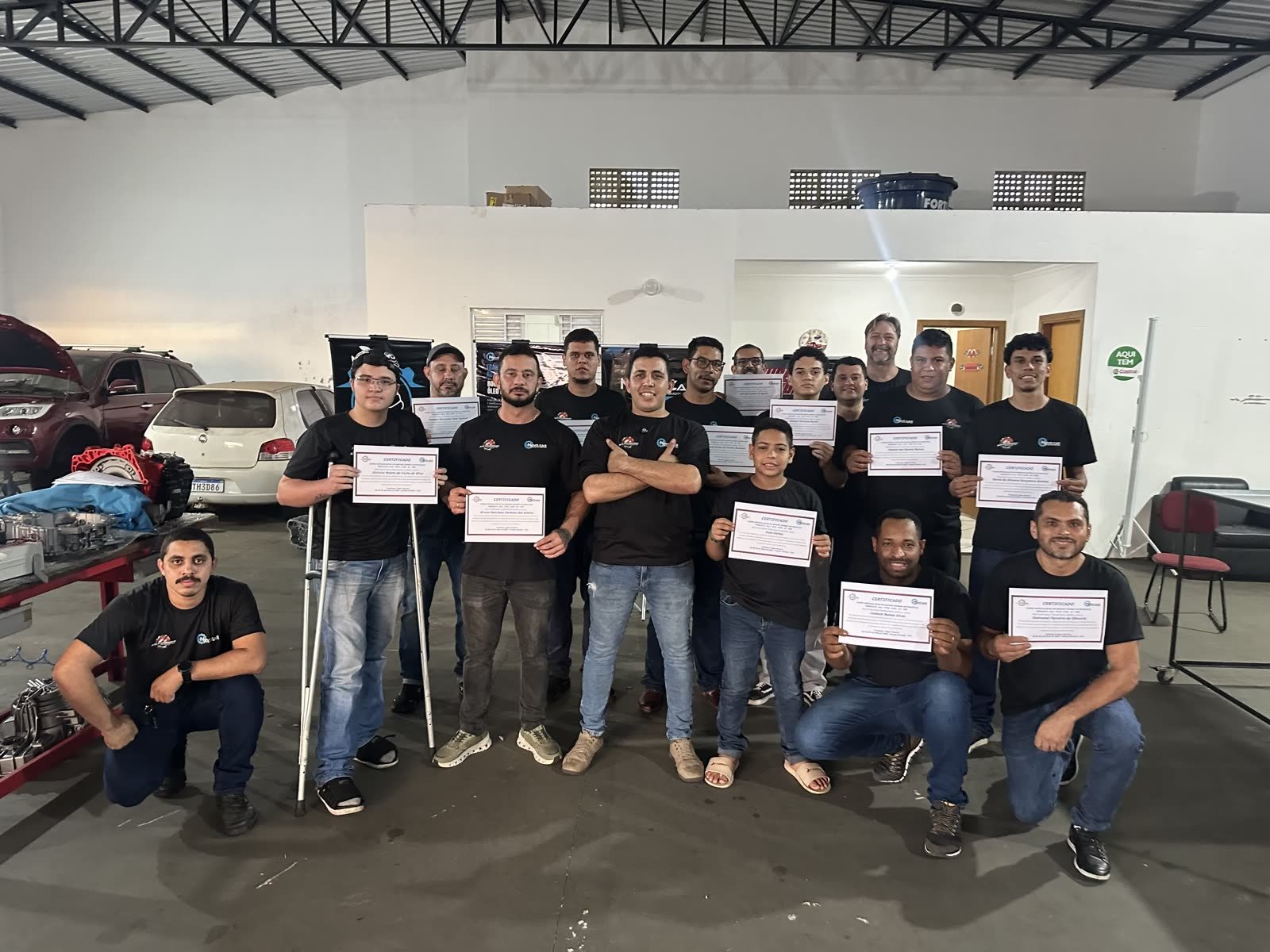 Turma formada do treinamento de reparo de câmbio automático segurando os certificados